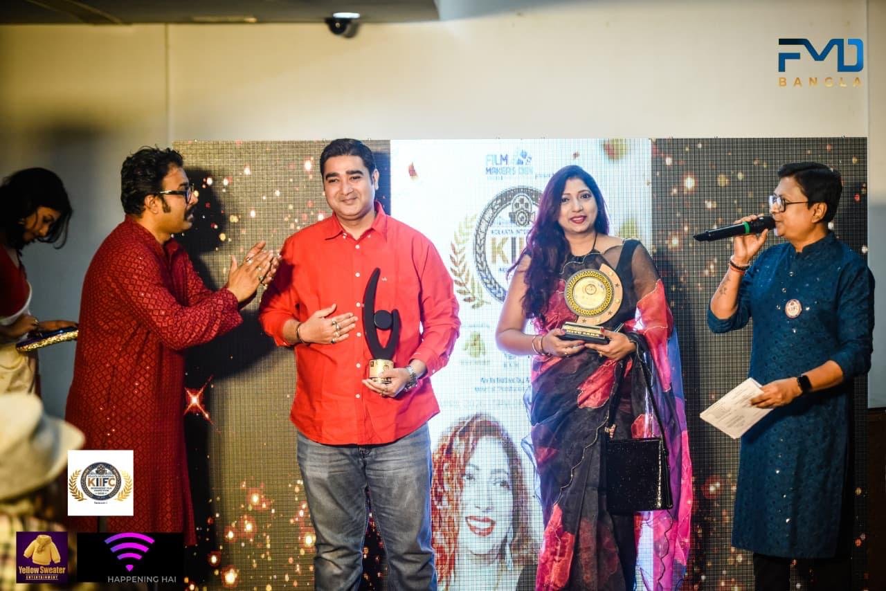 Receiving recognition at a Kolkata film & media awards evening.
